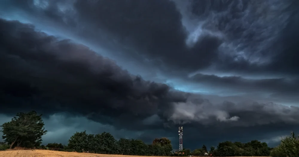 Mast vid ett fält under en molnig himmel